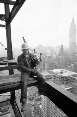 Arthur Rothstein and Frank Bauman - Construction worker playing a bagpipe and sitting on scaffolding, 1957